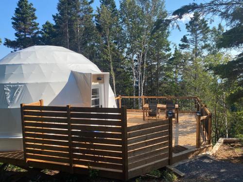 a yurt in the woods with a wooden deck at Domes Rocher Percé at Domaine Renard in Perce