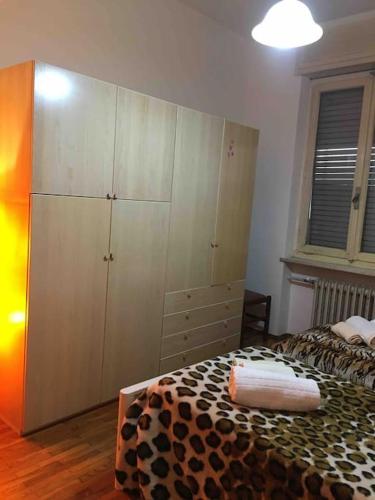 a bedroom with a bed and a large cabinet at LA CASA DI AURORA in Ivrea