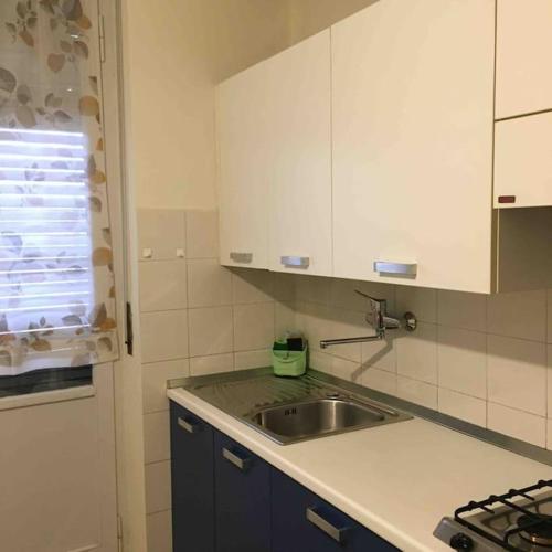 a kitchen with a sink and white cabinets at LA CASA DI AURORA in Ivrea