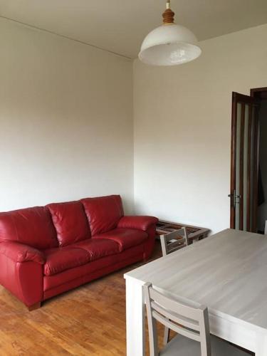 a living room with a red couch and a table at LA CASA DI AURORA in Ivrea
