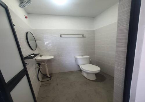 a bathroom with a white toilet and a sink at Perhentian Bay Chalet in Perhentian Island