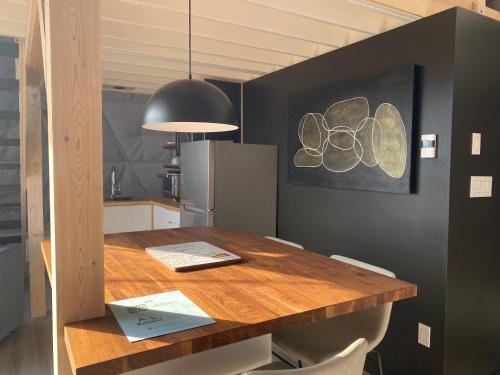 a dining room with a wooden table in a kitchen at Domes Rocher Percé at Domaine Renard in Perce