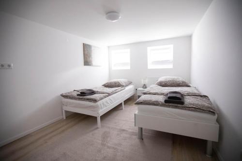 ハノーファーにある80qm - 4 rooms - privat parking - Keller-Basement - MalliBase Apartmentsの白い壁の客室内のベッド2台