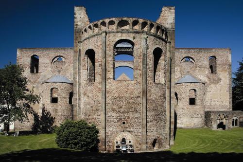 a large brick building with two towers on a grass field at Hotel am Kurpark in Bad Hersfeld
