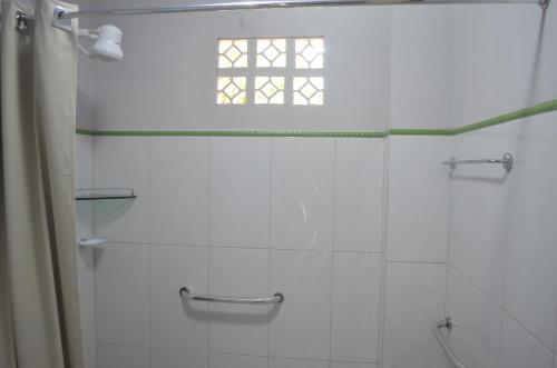 a white bathroom with a shower and a window at Pousada Encantos da Amazônia in Alter do Chao