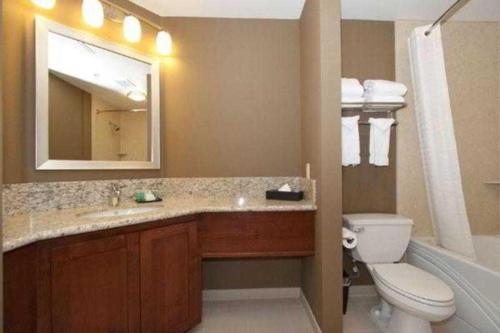 a bathroom with a sink and a toilet and a mirror at Hotel Med Park, an Ascend Collection Hotel in Sacramento