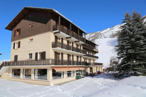 a large building with snow in front of a mountain at Le Relais du Galibier in Valloire