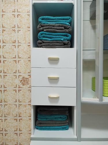 a closet with white drawers and towels at Five Oaks Hamburg in Hamburg
