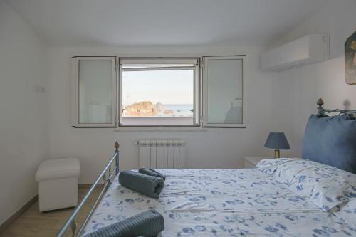 a bedroom with a bed and two windows at Casa Valastro in Aci Castello