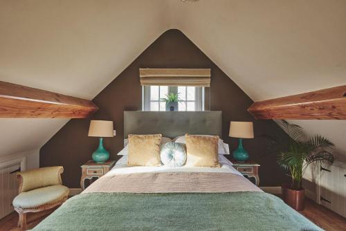 a bedroom with a large bed and two chairs at The Luxury Barn in Ashbourne