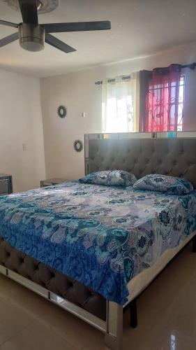 um quarto com uma cama com uma colcha azul em RESIDENCIAL PARADISE 3 J3 em Santiago de los Caballeros
