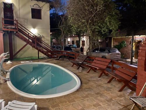 a hot tub in a courtyard with benches and a building at Pousada Encantos da Amazônia in Alter do Chao