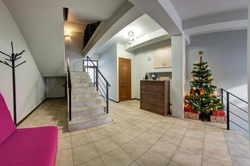 a christmas tree in a living room with a staircase at Dolyna Gir in Bukovel