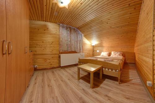 a bedroom with a bed in a wooden cabin at Dolyna Gir in Bukovel