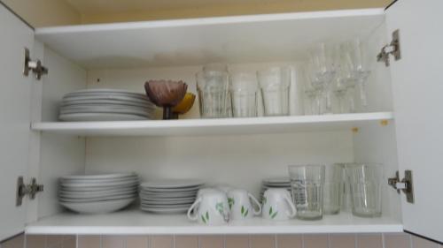 a cabinet filled with plates and glasses and dishes at Pipa Flat Solar in Pipa