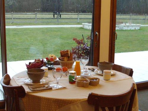 a table with food and wine glasses on it at Chambres et Table d'Hôtes Les Machetières in Langeais