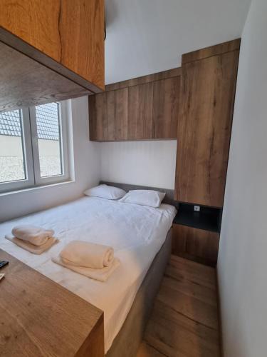 a bedroom with a bed with two towels on it at Apartmani Aspen in Jahorina