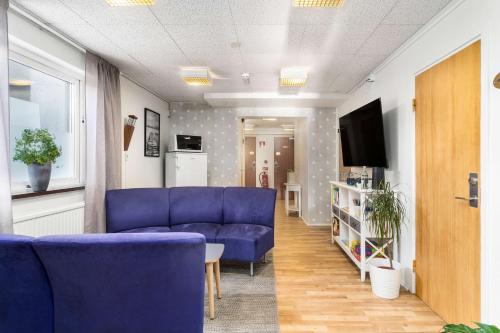 sala de estar con sofás azules y TV en Best Western Sjofartshotellet, en Oskarshamn