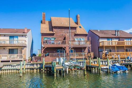 a house on a dock with chairs on the water at NEW Bijou Bayside Escape- 3beds, Balcony, Deck, Dock in Ocean City