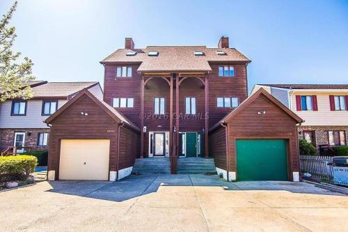 a house with two garages and two garage doors at NEW Bijou Bayside Escape- 3beds, Balcony, Deck, Dock in Ocean City