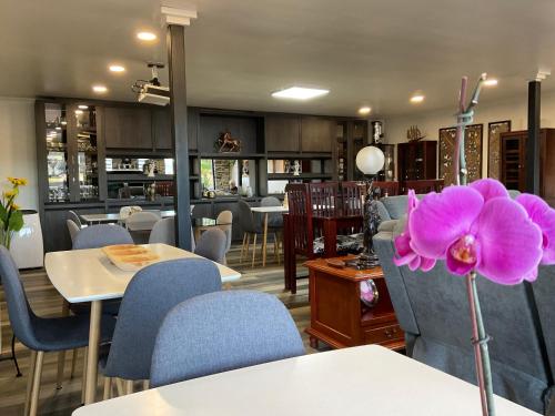 a restaurant with tables and chairs and a purple flower at Hostal Umantun in Dalcahue