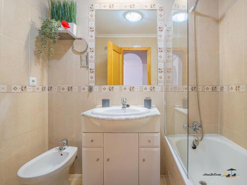 Atico Apartament Rose في مار ذي كريستال: حمام مع حوض ومرآة وحوض استحمام