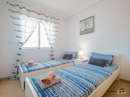 2 camas num quarto com uma janela em Atico Apartament Rose em Mar de Cristal