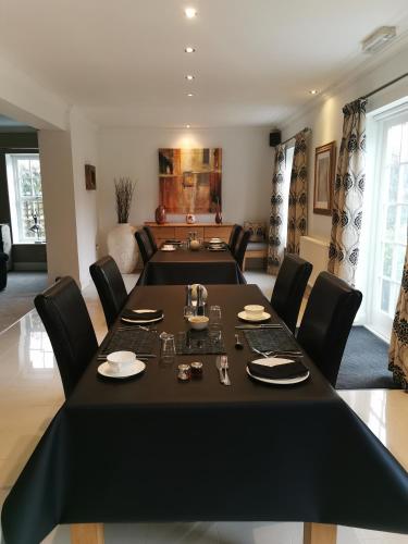 a dining room with a black table and chairs at Glangwili Mansion - Luxury 5 star Bed & Breakfast in Carmarthen