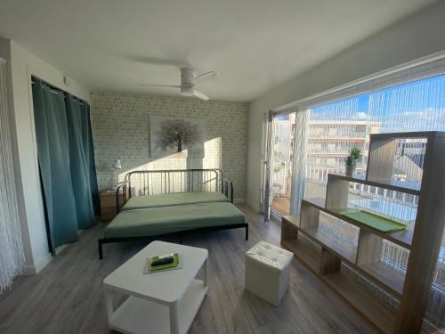 Cette petite chambre comprend un lit et une grande fenêtre. dans l'établissement Studio Amicie 27m2, balcon couvert, près centre-gare-cathédrale, wifi, à Reims