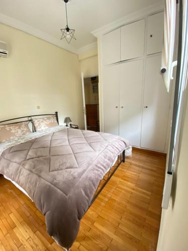 ein Schlafzimmer mit einem großen Bett und Holzboden in der Unterkunft Elegant Apartment in Athen