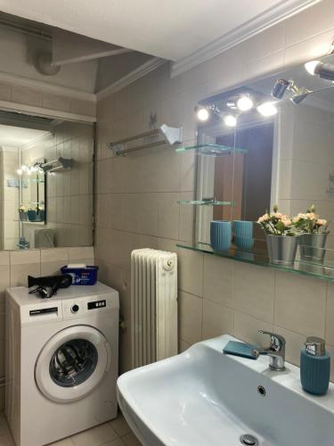 ein Badezimmer mit einer Waschmaschine und einem Waschbecken in der Unterkunft Elegant Apartment in Athen