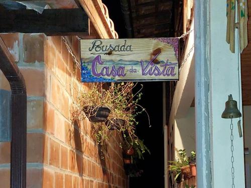 a sign for a restaurant on the side of a building at Pousada Casa da Vista in Visconde De Maua