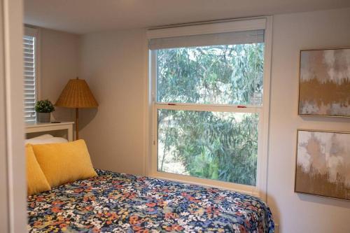 a bedroom with a bed and a large window at Coastal Tiny House 2 Queen Beds low loft in San Luis Obispo