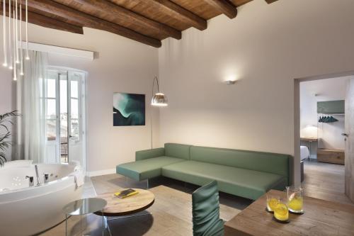 een woonkamer met een groene bank en een bad bij Casa Clat in Cagliari