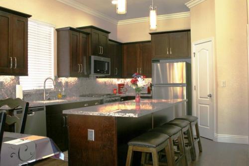 a kitchen with wooden cabinets and a kitchen island with bar stools at Chateau Sunnyside in Fresno