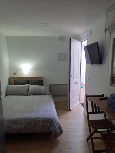 Un dormitorio con una cama, una mesa y un escritorio. en Apartamento Estudio B-1, en Madrid