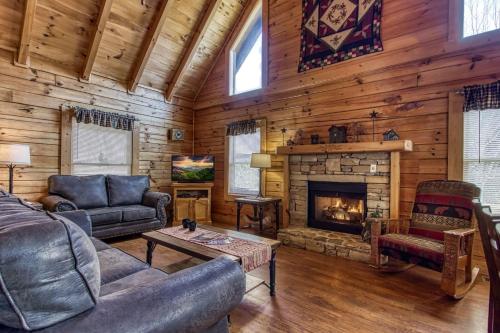 un salon avec cheminée dans une cabane en rondins dans l'établissement ER6 - On Eagles' Wings - Great location, Close to all the action! cabin, à Pigeon Forge