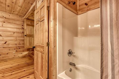 La salle de bains est pourvue d'une baignoire et d'une cabine de douche. dans l'établissement Cinema Falls - Great Location! - Convenient to Everything! cabin, à Pigeon Forge