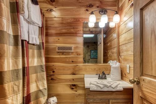 y baño con lavabo y espejo. en ER1 - Smoky Mountain Escape Great location - Close to town! cabin, en Pigeon Forge