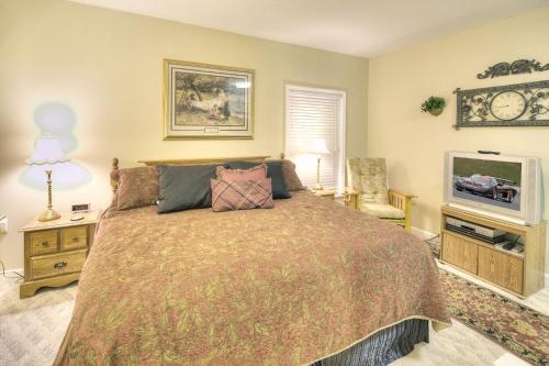 a bedroom with a large bed and a tv at Colonial Crest 107 - Great location! - You can walk to town! condo in Pigeon Forge