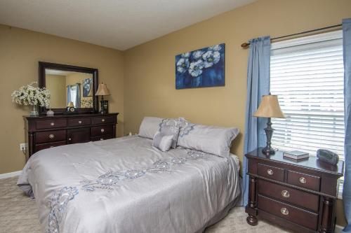 a bedroom with a bed and a dresser and a window at Colonial Crest 112 - Great location! - You can walk to town! condo in Pigeon Forge