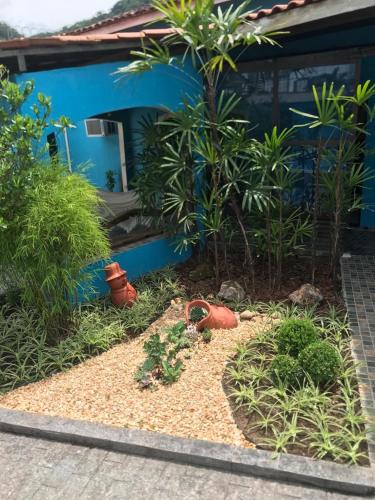 a garden in front of a house with plants at Casa com Piscina Canto do Forte - Praia Grande in Praia Grande