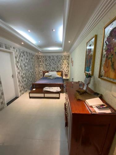 a bedroom with a bed and a dresser and a desk at Casa com Piscina Canto do Forte - Praia Grande in Praia Grande
