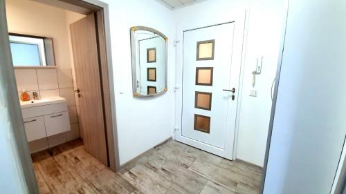 a bathroom with a mirror and a white door at Neuburg Apartment am Schloss in Neuburg an der Donau