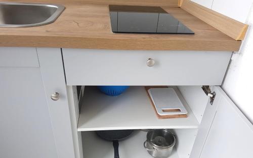a cupboard with a sink in a kitchen at Neuburg Apartment am Schloss in Neuburg an der Donau