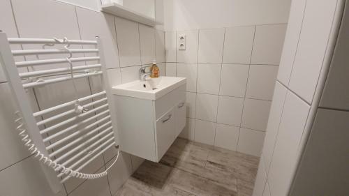 a white bathroom with a sink and a mirror at Neuburg Apartment am Schloss in Neuburg an der Donau
