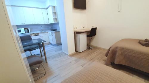 a room with a bed and a desk and a kitchen at Neuburg Apartment am Schloss in Neuburg an der Donau