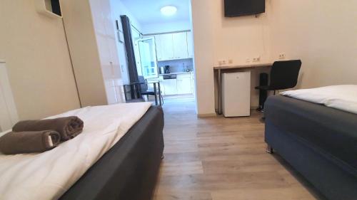 two beds in a room with a kitchen and a table at Neuburg Apartment am Schloss in Neuburg an der Donau