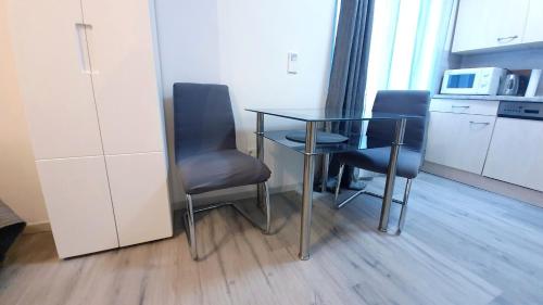 a dining room table with two chairs and a microwave at Neuburg Apartment am Schloss in Neuburg an der Donau