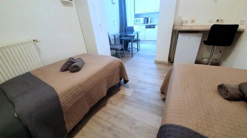 a bedroom with two beds and a kitchen with a table at Neuburg Apartment am Schloss in Neuburg an der Donau